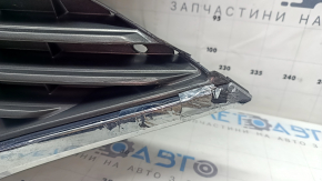 The grille assembly with the Nissan Quest 12-14 badge, camera, and molding is broken, worn, missing a fragment, broken fasteners, and peeling chrome.