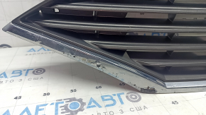The grille assembly with the Nissan Quest 12-14 badge, camera, and molding is broken, worn, missing a fragment, broken fasteners, and peeling chrome.