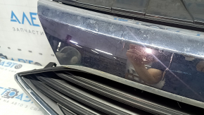 The grille assembly with the Nissan Quest 12-14 badge, camera, and molding is broken, worn, missing a fragment, broken fasteners, and peeling chrome.