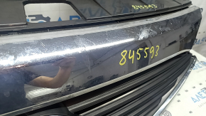 The grille assembly with the Nissan Quest 12-14 badge, camera, and molding is broken, worn, missing a fragment, broken fasteners, and peeling chrome.