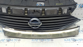 The grille assembly with the Nissan Quest 12-14 badge, camera, and molding is broken, worn, missing a fragment, broken fasteners, and peeling chrome.