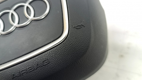 The Audi Q8 19-25 driver's steering wheel airbag is black and scratched.