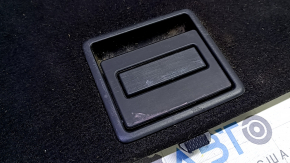 The trunk floor of a 15-17 Toyota Prius V is black, with scratches on the handle.