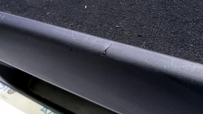 The battery cover of a 15-17 Toyota Prius V is black and scratched.
