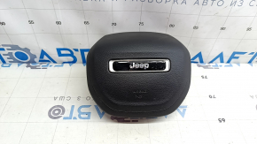 The driver's side airbag in the Jeep Compass 22-25 is black and has a rusty squib.