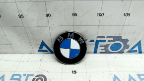 The BMW 3 G20 19-24 trunk lid logo emblem is dented.