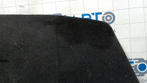 The trunk floor of a 2016-2017 Kia Optima is black, worn, has dents, and needs cleaning.