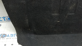The trunk floor of a 2016-2017 Kia Optima is black, worn, has dents, and needs cleaning.