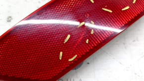 The rear right reflector of a Ford Escape MK3 13-19 is cracked and scratched.