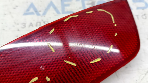 The rear right reflector of a Ford Escape MK3 13-19 is cracked and scratched.