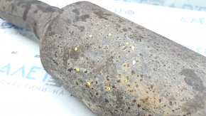 The rear catalytic converter of a Ford Escape MK4 2023-25 hybrid is sawn off, rusty, and dented.