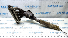 The exhaust manifold with a catalytic converter for a Ford Fusion mk5 17-20 hybrid is rusty and missing a fragment.