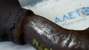 The exhaust manifold with a catalytic converter for a Ford Fusion mk5 17-20 hybrid is rusty and missing a fragment.