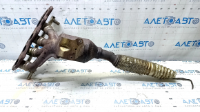 The exhaust manifold with a catalytic converter for a Ford Fusion mk5 17-20 hybrid is rusty and missing a fragment.