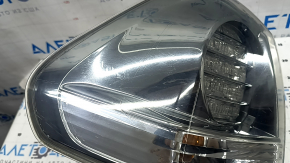 The outer left fender light of a Lexus RX350 RX400h 06-07 is dark and scratched.