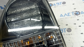 The outer left fender light of a Lexus RX350 RX400h 06-07 is dark and scratched.