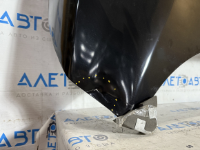 The hood of a 2017-2019 Nissan Rogue Sport is bare steel and dented.