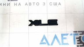 The XLE emblem on the tailgate of the Toyota Highlander 20-25 is black.