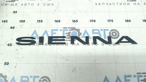 The SIENNA emblem on the trunk door of a Toyota Sienna 21-24 is worn.