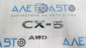 The Mazda CX-5 2022-2025 CX5 AWD tailgate emblem is broken.