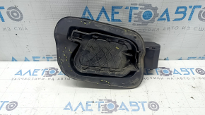 The fuel filler flap housing of a VW Tiguan 18-24 has broken fasteners, a torn seal, and a crack in the housing.