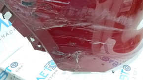 The bare rear bumper of a Buick Encore 17-22 without BSM, without reflector brackets, is dented, torn, has broken fasteners and scratches.