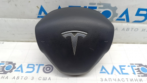 The Tesla Model Y 20-25 driver's steering wheel airbag is black and scratched.