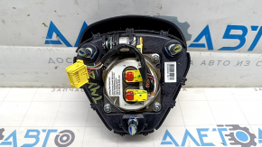 The Tesla Model Y 20-25 driver's steering wheel airbag is black and scratched.