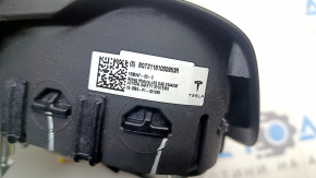 The Tesla Model Y 20-25 driver's steering wheel airbag is black and scratched.