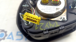 The Tesla Model Y 20-25 driver's steering wheel airbag is black and scratched.