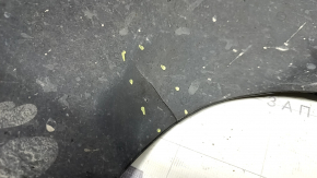 The front right fender liner of a 17-22 Buick Encore is dented and has tears.