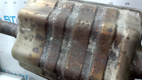 The rear muffler with the barrel of a 19-21 LUV Buick Encore is rusty and the barrel is dented.