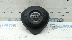 The driver's side airbag in the steering wheel of a Nissan Rogue 17-20 is black, scratched, and has a rusty squib.