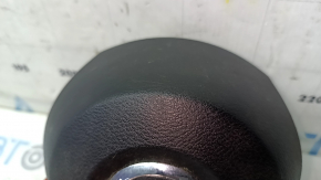 The driver's side airbag in the steering wheel of a Nissan Rogue 17-20 is black, scratched, and has a rusty squib.