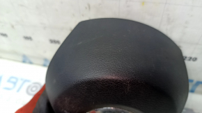 The driver's side airbag in the steering wheel of a Nissan Rogue 17-20 is black, scratched, and has a rusty squib.