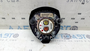 The driver's side airbag in the steering wheel of a Nissan Rogue 17-20 is black, scratched, and has a rusty squib.