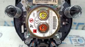 The driver's side airbag in the steering wheel of a Nissan Rogue 17-20 is black, scratched, and has a rusty squib.