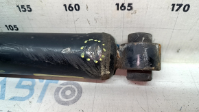 The rear left shock absorber of a Nissan Rogue 14-17 AWD is dented.