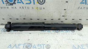The rear left shock absorber of a Nissan Rogue 14-17 AWD is dented.