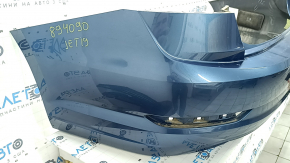 The rear bumper of a 19-21 VW Jetta is bare and blue, with paint peeling off.
