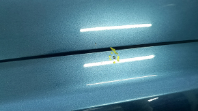 The rear bumper of a 19-21 VW Jetta is bare and blue, with paint peeling off.