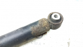 The rear left shock absorber of a VW Jetta 19-26 is rusty.