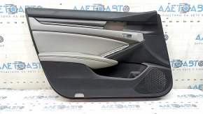 The front left door panel of a 1922 Honda Accord is black with a light gray leather insert. The armrest is light gray leather, and the wood-like molding has scratches and wear.