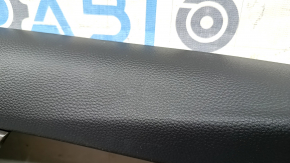 The front left door panel of a 1922 Honda Accord is black with a light gray leather insert. The armrest is light gray leather, and the wood-like molding has scratches and wear.