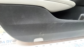 The front left door panel of a 1922 Honda Accord is black with a light gray leather insert. The armrest is light gray leather, and the wood-like molding has scratches and wear.
