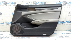 The front right door panel of a 1922 Honda Accord is black with a light gray leather insert. The armrest is light gray leather, and the wood-like molding has scratches and wear.