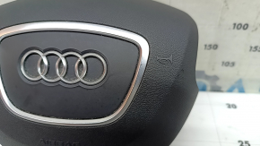 The steering wheel airbag for the driver's side of the Audi Q5 8R 13-17 is black and scratched.