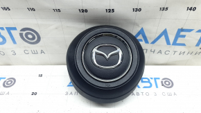 The Mazda CX-9 16-23 driver's steering wheel airbag is worn.