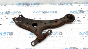 The front left lower control arm of a Toyota Camry v40 is rusty and the silent block is torn.