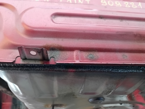 The rear panel of a Toyota Camry v40 is red and rusty, with a broken stud.